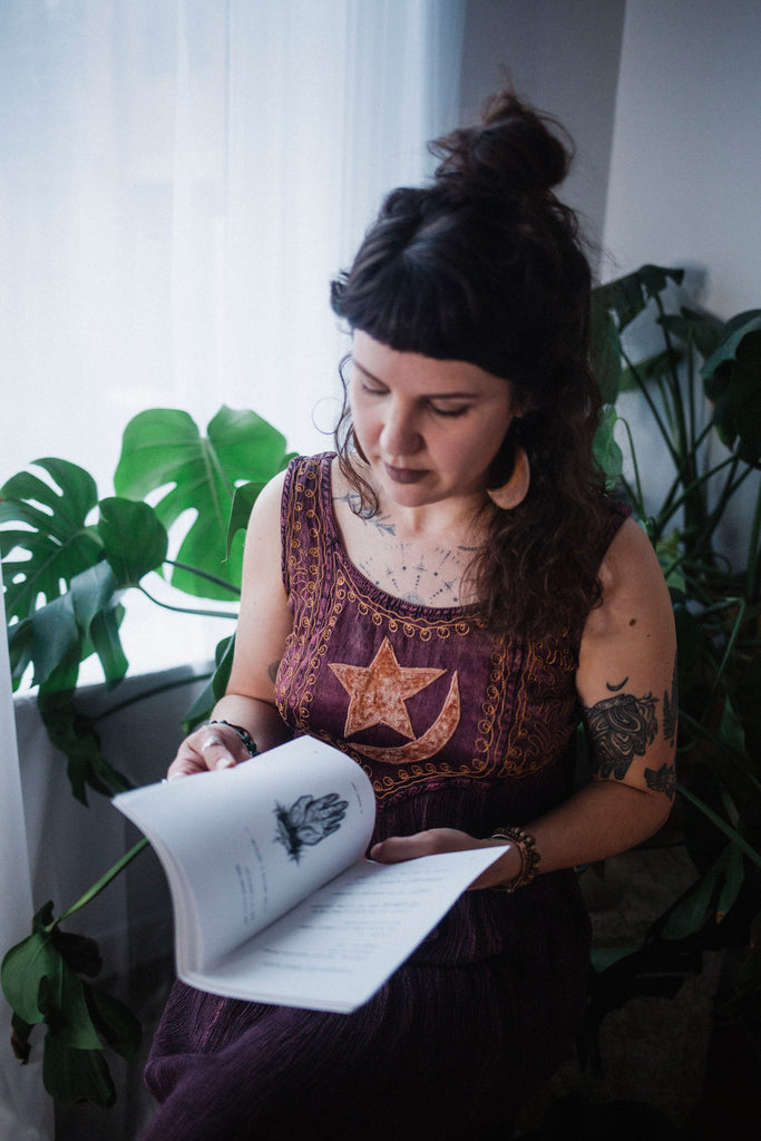 Rachael Amber flips through her cyclical poetry book "written on the trees that teach me, forgive me..."